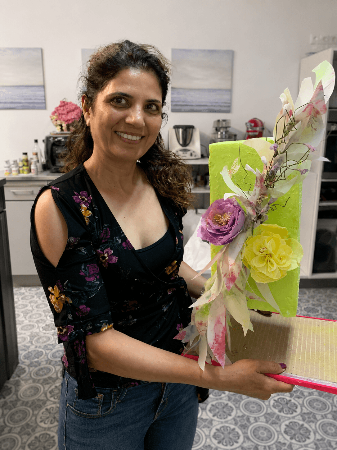 Versha holding one of her custom cakes